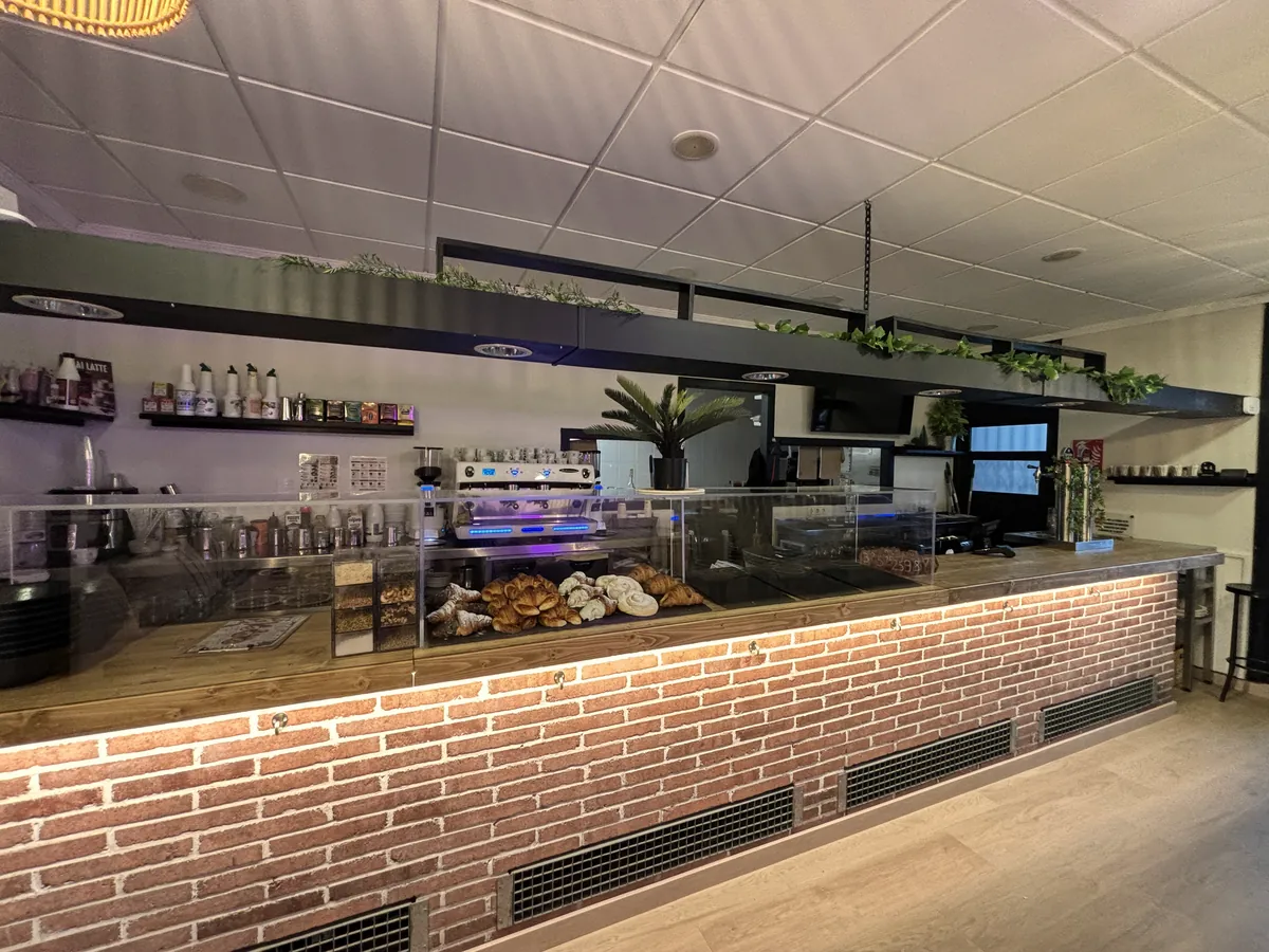 Barra del local amb la vitrina de brioixeria i la cafetera